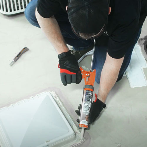 elite rv technician repairing roof sealant on rv
