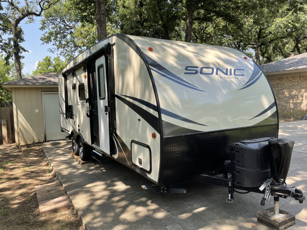 a venture sonic rv parked in a driveway