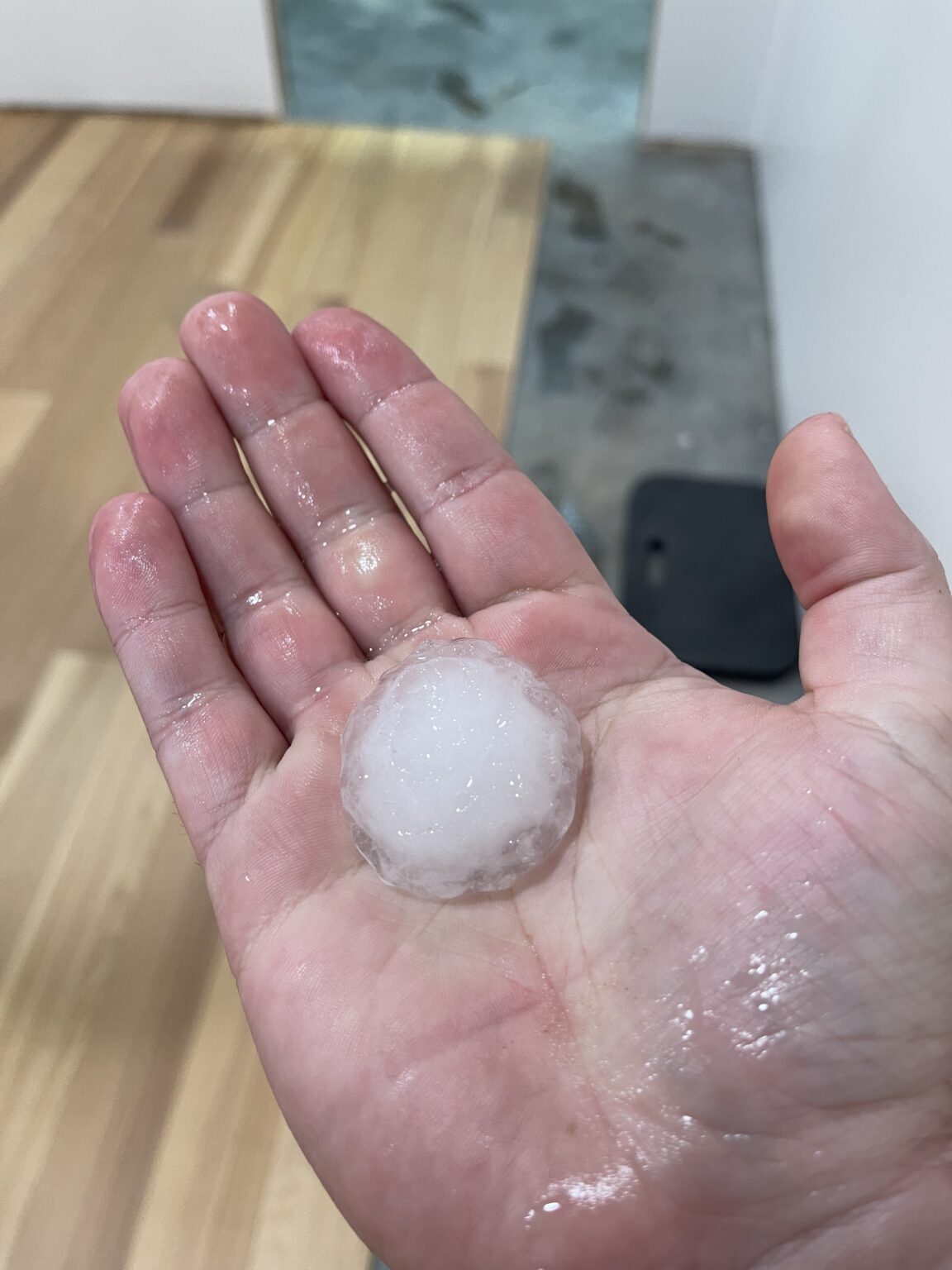 person holding walnut size hailstone